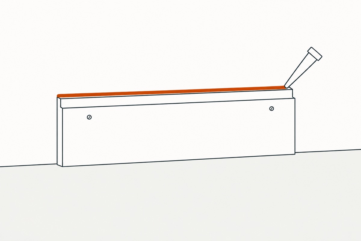 A nozzle running a thin bead along the line where the trim's top edge meets the wall
