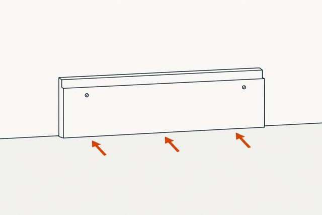 The trim back flat on the wall with two nail heads near its top edge and three arrows pressing it home